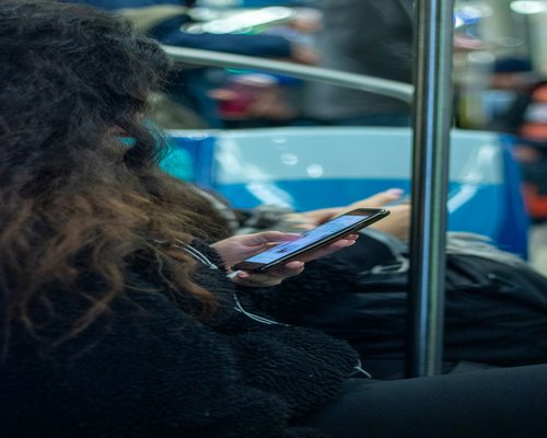 Persona leyendo en su celular mientras va en transporte público